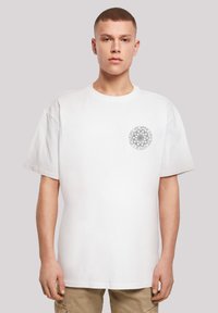 White cotton t-shirt with a round neckline, short sleeves, and a circular gray graphic on the left chest. Standard fit and smooth texture.