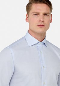 Light blue checkered dress shirt with a button-down collar, featuring a textured fabric and a slim-fit design.