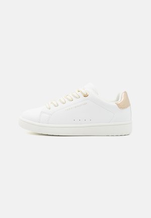 White sneaker with smooth synthetic upper, gold eyelets, and a pale gold accent on the heel. Features perforations near the toe for ventilation.