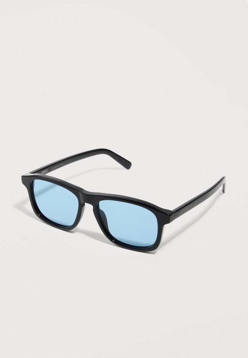 Black rectangular sunglasses with light blue tinted lenses resting on a white surface.