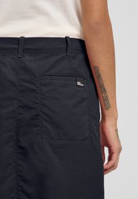 Navy katoenmengsel shorts met een achterzak, gestikte details en een klein logo-opdruk. Zachte textuur met een rechte snit.