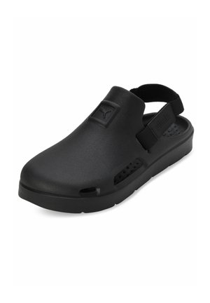 Scarpe slip-on nere realizzate in materiale simile alla gomma con una suola spessa, dotate di un cinturino sul retro e fori di ventilazione sui lati.