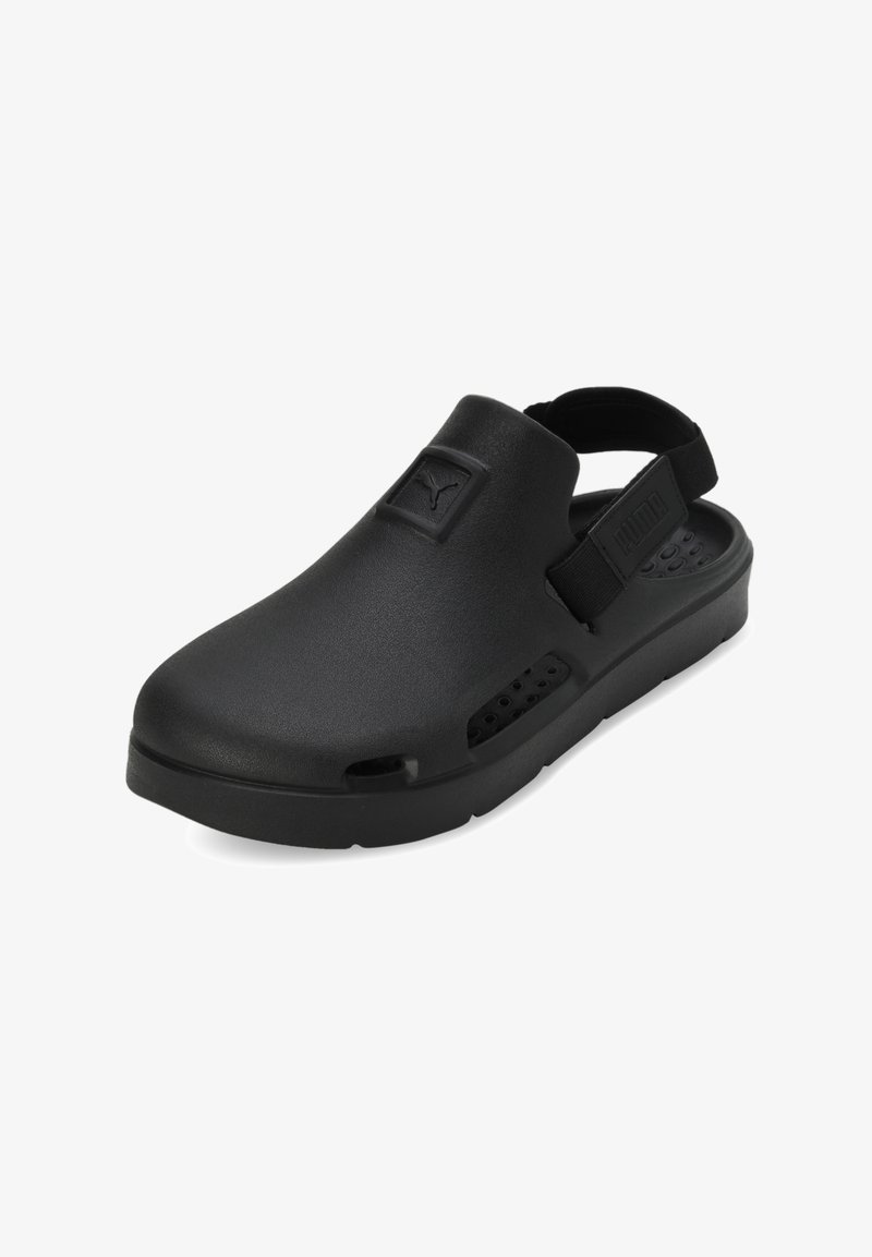 Černé slip-on boty vyrobené z pryžovému materiálu s tlustou podrážkou, vybavené zadním páskem a ventilačními otvory po stranách.