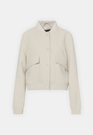 Chaqueta bomber de color beige claro, hecha de una mezcla de algodón, con un cuello acanalado, dos bolsillos frontales y cierre de botones a presión.