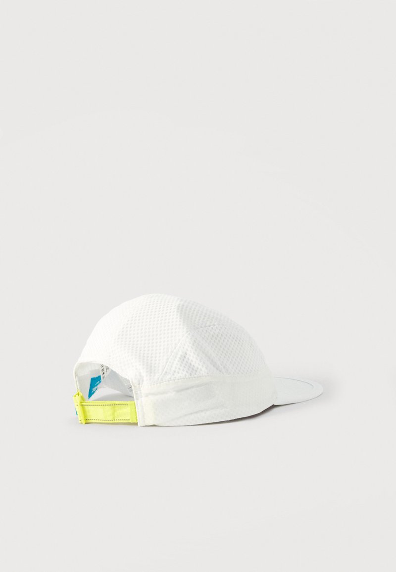 White mesh baseball cap lying on its side showing adjustable neon yellow strap and blue tag inside.
