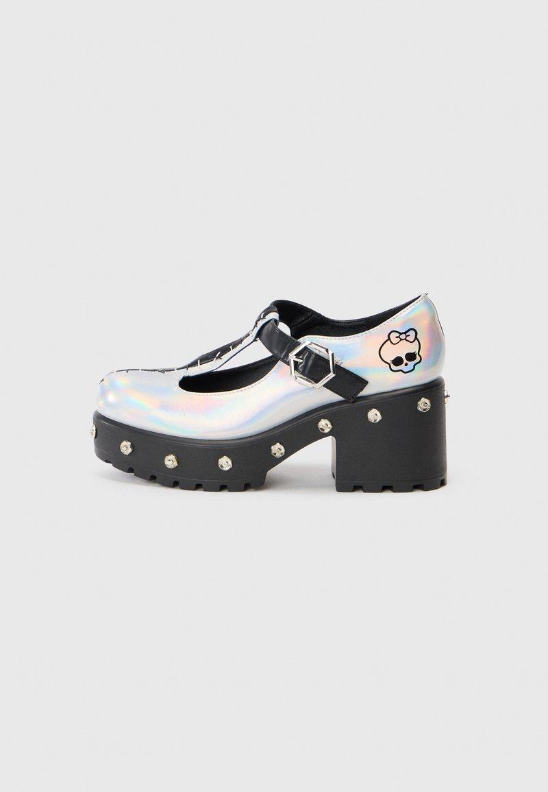 Sapatos plataforma holográficos com um design de tira em T, apresentando detalhes em preto, tachas prateadas na sola e um gráfico de caveira na lateral.