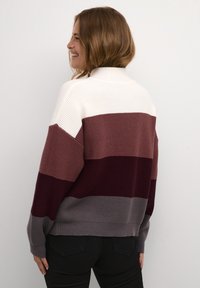 Maglione lavorato a maglia con collo alto, caratterizzato da righe orizzontali in crema, malva, bordeaux e grigio. Vestibilità ampia con texture a coste.