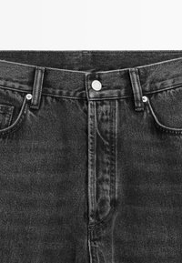 Czarne dżinsy z denimu z wysokim stanem i zapięciem na guziki, pięciokieszeniowym fasonem oraz kontrastującymi przeszyciami. Materiał jest gładki z lekkim połyskiem.