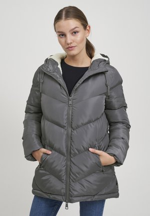 Pelēks pūkains mētelis ar rāvējslēdzēju, kapuci un diagonālu quilted rakstu. Iekšpuse ir mīksta auduma un tam ir sānu kabatas.