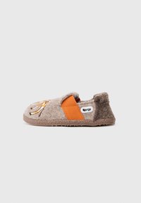 Sabán gris con una correa de textil naranja, que presenta un diseño bordado en la parte superior. Suela de goma con un acabado texturizado.