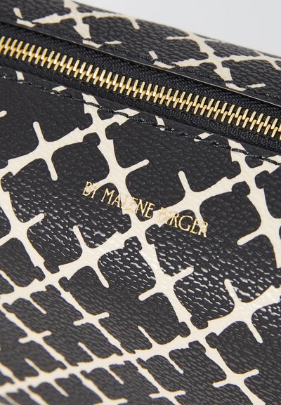 Svart och krämfärgad mönstrad läderpung med en texturerad yta, med en guldfärgad dragkedja och varumärkeslogotyp i guldtext.