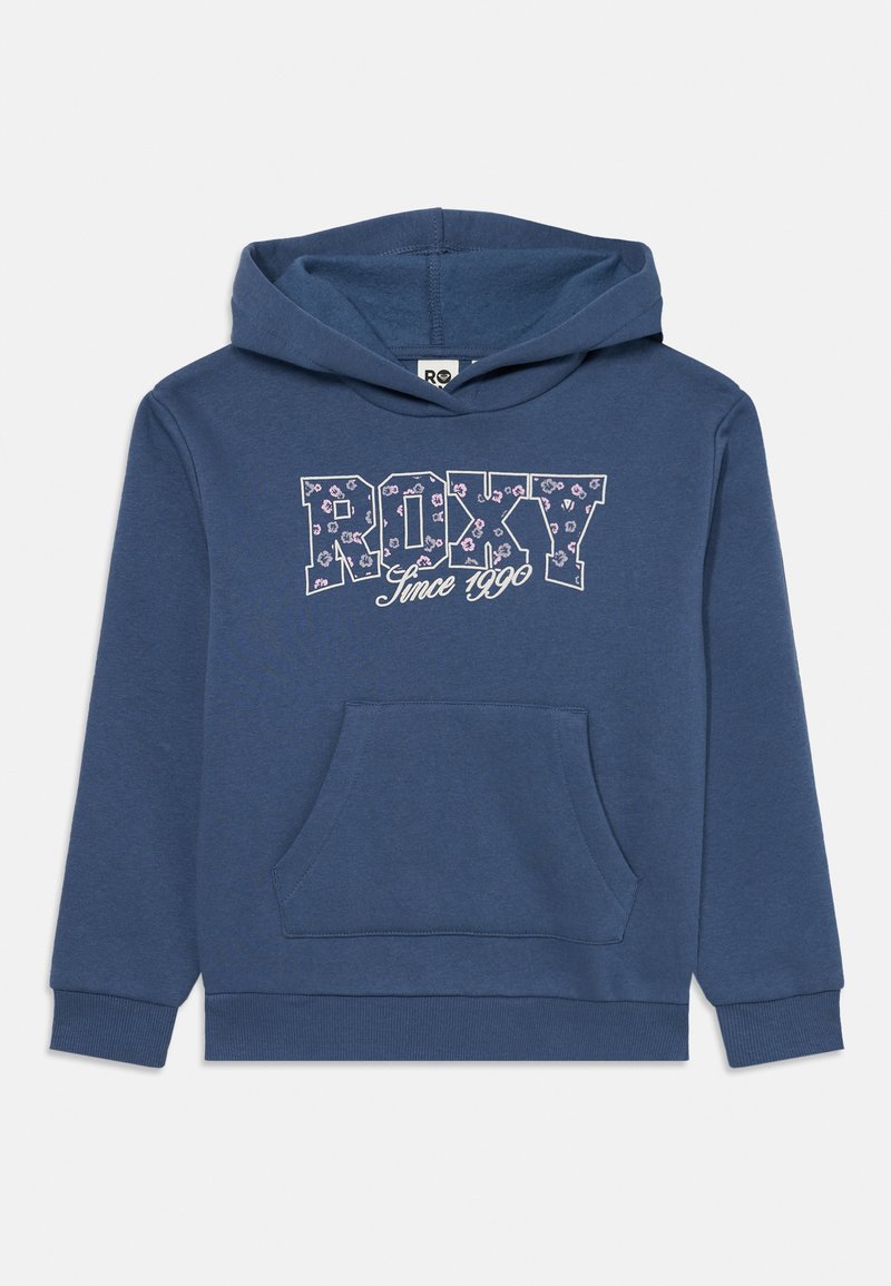 Zila kapucīna džemperis ar priekšējo kabatu, uz krūtīm drukāts "ROXY" ar ziedu rakstu un teksts "Kopš 1990. gada" zem tā.