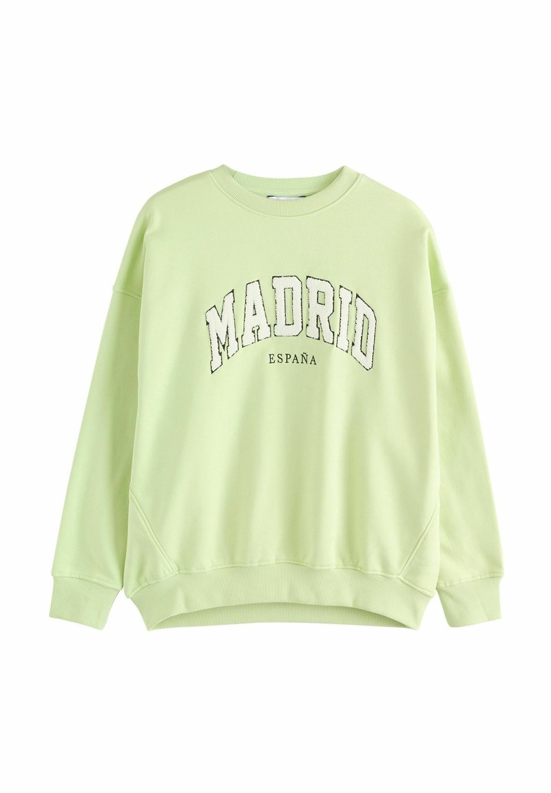 Sudadera verde claro con cuello redondo, hombros caídos y puños acanalados. Presenta las palabras "MADRID" y "ESPAÑA" impresas en negro en la parte delantera.