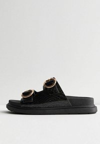Sandales à glissière noires avec deux brides à boucle, présentant un design texturé en similicuir effet peau de serpent et une semelle plate épaisse en caoutchouc.