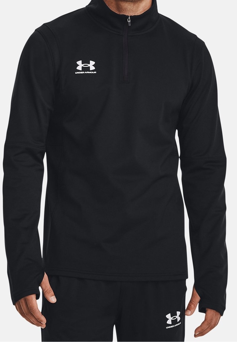 Svart zip-up-pullover i mjukt tyg med långa ärmar. Har hög krage och vit Under Armour-logotyp på bröstet.