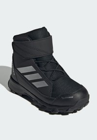 Black hiking boot with a textile upper, Velcro strap, and reflective gray accents. Features a rugged sole for improved traction. ClimaWarm branding visible.