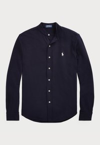 Granatowa koszula z długim rękawem z bawełny, z kołnierzykiem zapinanym na guziki, białymi guzikami i małym białym haftowanym logo na piersi.