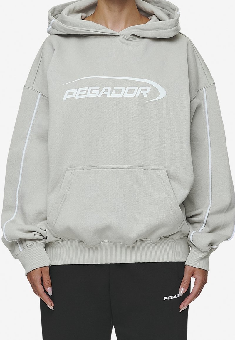 Sudadera gris claro con capucha y logotipo blanco "PEGADOR". Cuenta con puños y dobladillo acanalados, bolsillo tipo canguro y ribetes laterales en contraste.