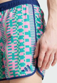 Pohodlné sportovní šortky s vzorem v růžové, zelené a modré, s texturovaným designem a tmavě modrým pasem a detaily s logem.