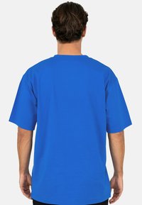 T-shirt en coton bleu à manches courtes, col rond et coupe décontractée. Le tissu semble lisse, sans motifs ni accents supplémentaires.