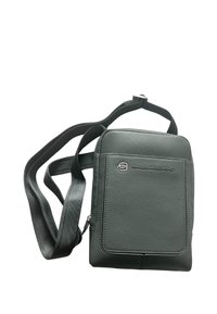 Borsa verde in pelle con una texture liscia, forma rettangolare e tracolla regolabile. Presenta un logo e una tasca frontale per riporre gli oggetti.