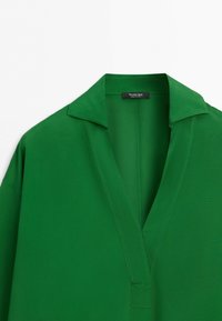 Green shirt with a deep V-neck and collar, showing a black label inside with the brand name Massimo Dutti.