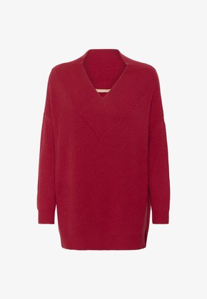 Rød ribbet sweater med dyb V-hals og lange ærmer. Har sideslids og en struktureret strik, der skaber en afslappet, oversized pasform.