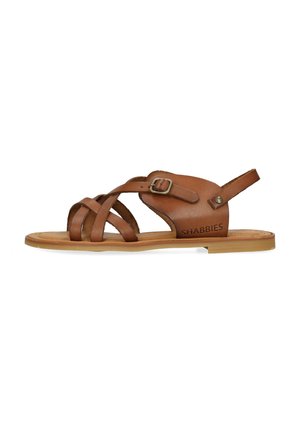 Sandale en cuir marron avec des brides croisées, boucle réglable et semelle en caoutchouc plate. Présente une tige texturée et un logo sur le côté.