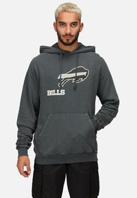 Sudadera gris con un bolsillo frontal, que presenta un logo de búfalo en blanco y gris y el texto "BILLS". El material parece suave y tiene un corte holgado.