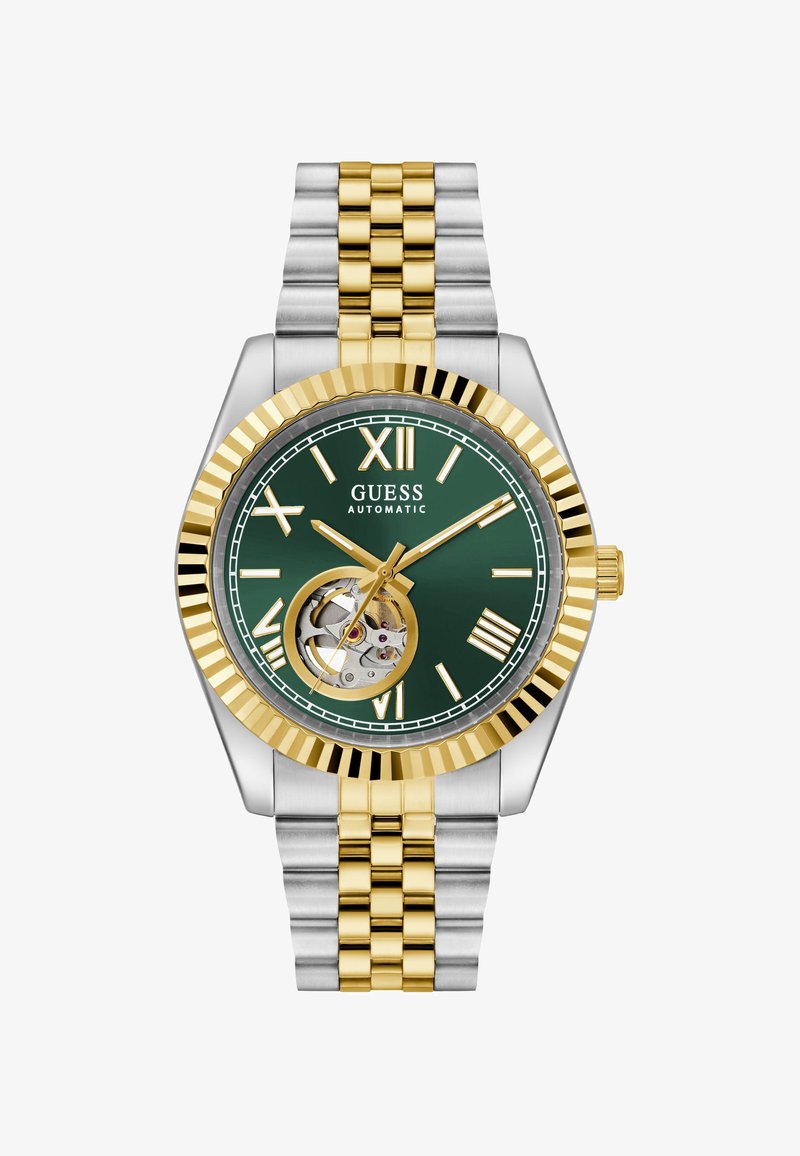 Ceas automatic din aur și argint cu un cadran verde. Caracteristicile includ numerale romane, display deschis al mecanismului și un bezel texturat.