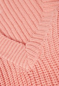 Maglione lavorato a maglia in rosa chiaro, con motivi a coste testurizzate e un design a chevron sulla scollatura. Materiale in filato morbido e spesso.