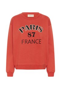 Rdeča majica s dolgimi rokavi, rebrasti manšeti in natisnjeno "PARIS 87 FRANCE" v črni barvi spredaj.