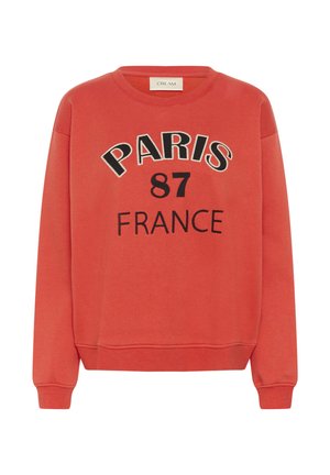 Sweat-shirt rouge à manches longues, avec des bords côtes aux poignets, et "PARIS 87 FRANCE" imprimé en noir sur le devant.