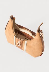 Beige Streifen auf einer taubengrauen Wildleder-Handtasche, mit goldenem Verschluss, oberem Reißverschluss und sichtbarem Innenreißverschluss, vor einem weißen Hintergrund.