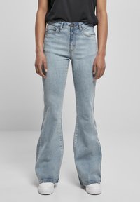 Ljusblå denim jeans med utsvängd byxa och medelhög midja, femfickorsdesign och subtila sömnadsdetaljer längs sömmarna.