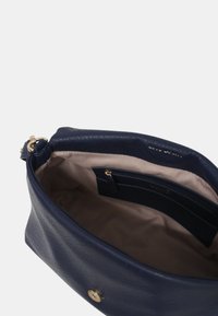 Borsa a tracolla in pelle blu navy con una finitura liscia, dotata di chiusura a scatto magnetico e una tasca interna per l'organizzazione.