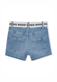 Bermudas de mezclilla en azul claro con una cinturilla con logotipo negro en contraste, que cuentan con dos bolsillos traseros y un dobladillo limpio.