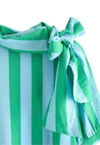 Grön- och ljusblå randig plagg med knuten axeldetalj och mjukt, texturerat tyg, med varierande randbredd.