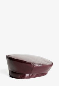 Burgundy nahkapipo, jossa on sileä ja kiiltävä pinta. Sillä on pyöreä muoto ja tasainen lippa, jota korostaa ommeltu yksityiskohtaisuus.