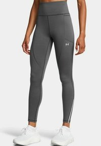 Grijze high-waisted leggings met een zachte textuur, voorzien van een taps toelopende pasvorm, zijnaden en witte accenten langs de onderbenen.