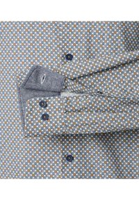 Hemd mit hellblauem Grund, gemustert mit braunen und blauen geometrischen Formen, ausgestattet mit blauen Knöpfen und einem umgeschlagenen Manschette mit gestreiftem Innenfutter.