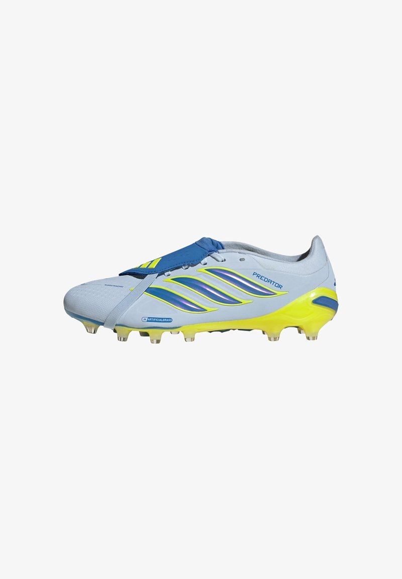 Chaussure de football Adidas Predator blanche et jaune avec des détails bleus, dessus synthétique et crampons conçus pour les surfaces en gazon artificiel.