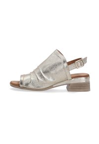 Metallic sølv åbentået sandal med slouch-design, perforeret tekstur og lav blokhæl. Har en justerbar ankelrem.