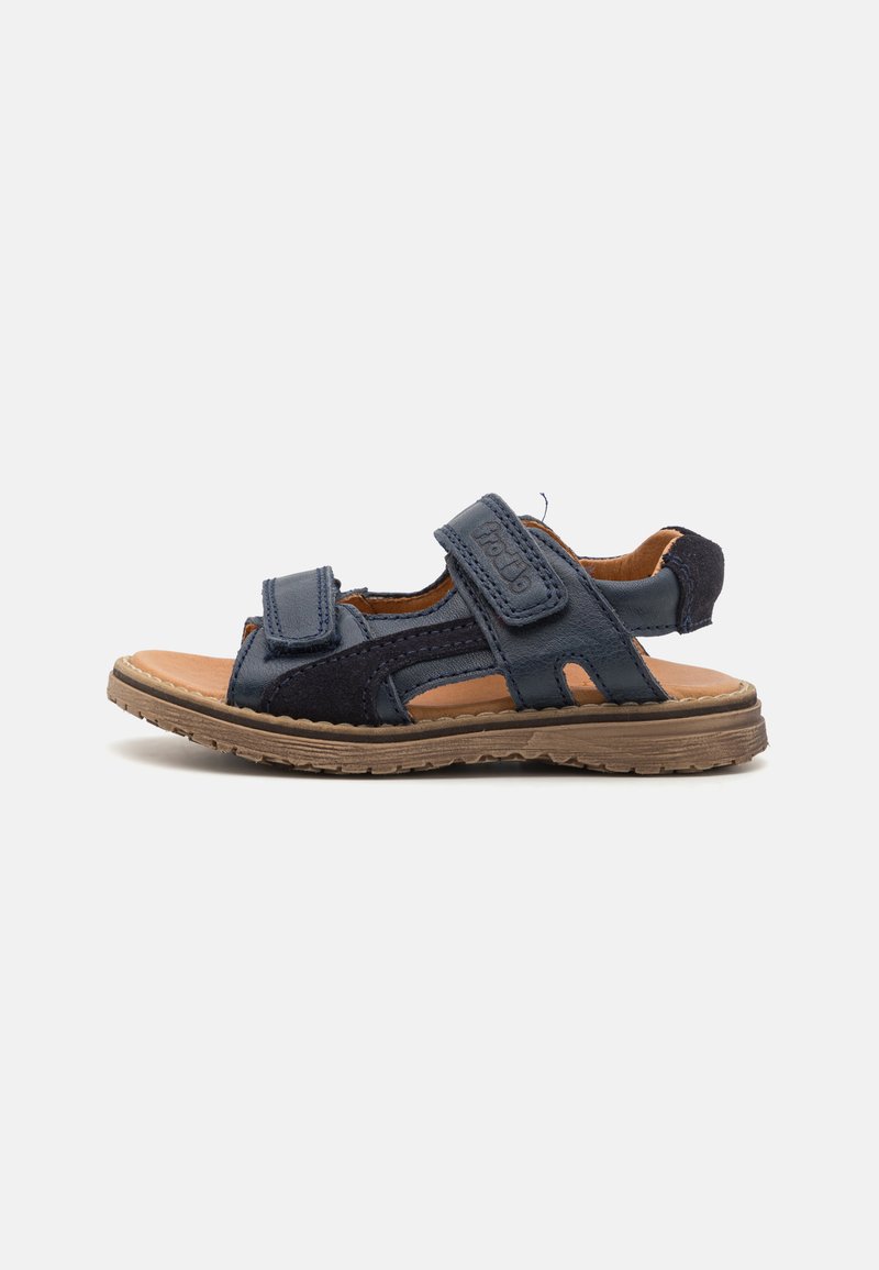 Mörkblå sandaler gjorda av läder och mocka, med två justerbara kardborreband, en brun fotbädd och en texturerad gummisula.
