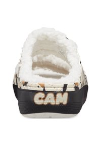 Chaussure décontractée à enfiler avec un intérieur moelleux blanc, un tissu à motifs représentant des animaux de dessin animé et une semelle en caoutchouc noire. Logo "CAM" en beige.