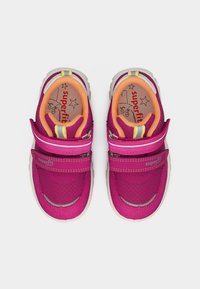 Παιδικά αθλητικά παπούτσια σε ματζέντα και πορτοκαλί με λουράκια Velcro, λευκές σόλες και λογότυπο "superfit" εσωτερικά και στα λουράκια, εμφανιζόμενα από πάνω.