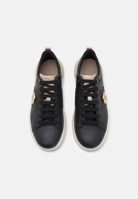 Sneaker in pelle nera con finitura testurizzata, dotate di lacci neri, accenti beige e un logo dorato sul lato. Suole in gomma bianca.