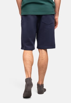 Marineblaue Shorts aus weichem Stoff, mit einem elastischen Bund und einer Gesäßtasche mit einem auffälligen, diamantförmigen Design.