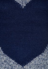 Suéter de punto con un patrón geométrico de corazón en azul marino y azul claro. La textura es suave con un acabado acanalado.