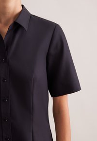 Granatowa koszula z krótkim rękawem, klasycznym kołnierzykiem, zapinana na guziki z przodu, o gładkiej, matowej fakturze tkaniny.